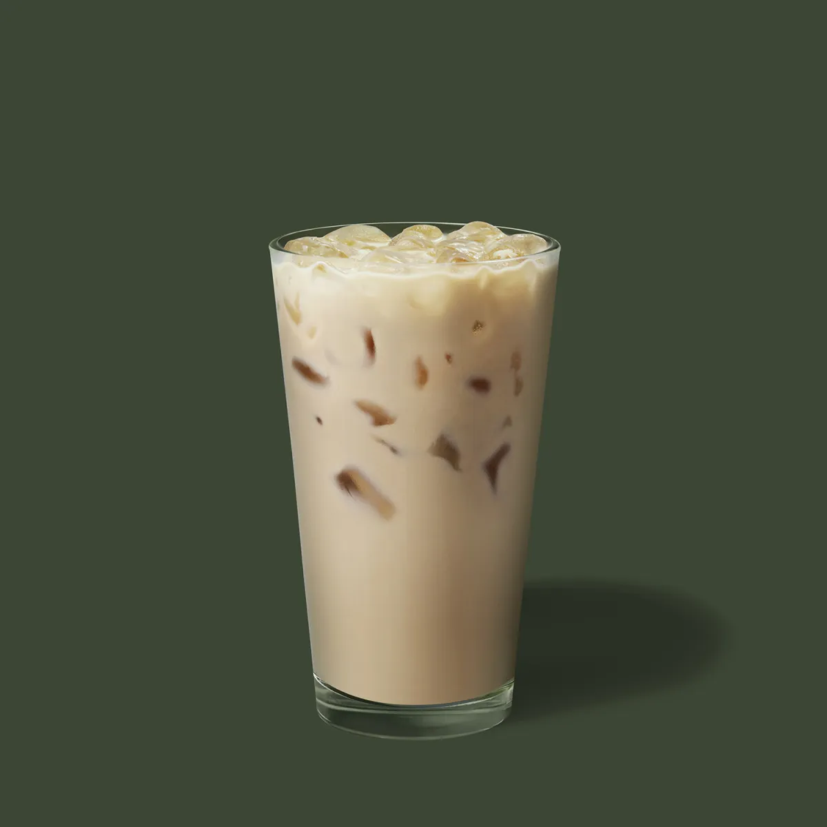 Iced Chai Tea Latte dans un grand verre transparent sur fond vert